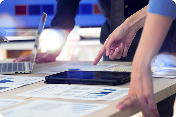 person pointing to an ipad and business presentation